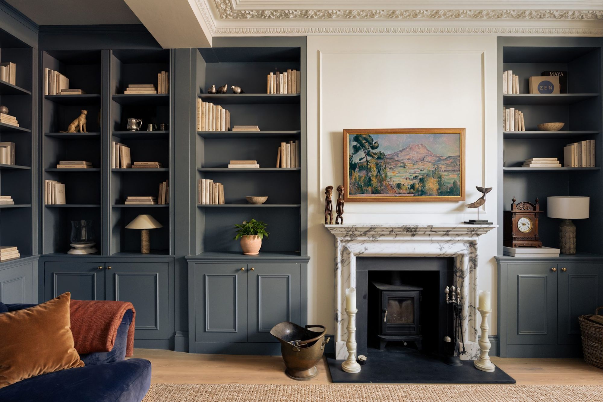 Living room with blue-grey built-in shelving and a marble fireplace